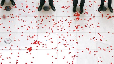 Soldiers stand among fallen tissue paper poppies during the annual Lloyd's of London Remembrance Day service at the Lloyd's Building in the City of London on November 11, 2014. Suzanne Plunkett / Reuters