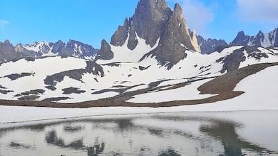 Zabih Afzali sits at the edge of a lake at the Mount Shah Fuladi base camp, June 2020. Courtesy Zabih Afzali