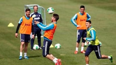 Sergio Ramos, centre, performs for Real Madrid teammates Xavi Alonso, left, and Mesut Ozil, right, in training for the Copa del Rey. Juan Carlos Hidalgo / EPA