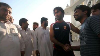 Abdul Haq, centre right, a lorry driver who impressed the Pakistani coaches, is greeted by fans at Sheikh Zayed Cricket Stadium.