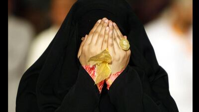 A woman wearing a full-faced veil cries as she prays after casting seven stones at a pillar that symbolises Satan on the second day of Eid al-Adha in Mina, Saudi Arabia. Amr Abdallah Dalsh / Reuters