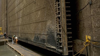 Workers from the Panama Canal Authority weld the bottom of the Miraflores floodgate during routine maintenance. Arnulfo Franco / AP Photo