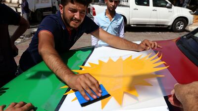 An Iraqi Kurdish man decorates a car with the Kurdish flags ahead of the upcoming independence referendum in Erbil, the capital of the autonomous Kurdish region of northern Iraq, on September 7, 2017. AFP PHOTO / SAFIN HAMED