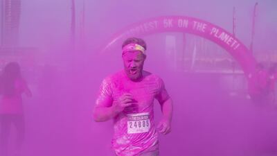 A participants races through plumes of pink powder to finish the 5km run. Clint McLean for The National