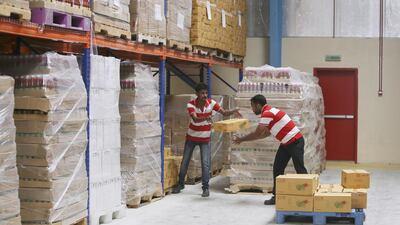 Workers load a palette with boxes of food at the Chilly Willy manufacturing facility.