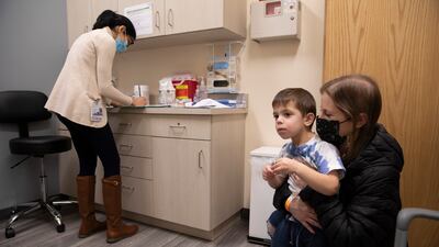 A mother with her child, 3, at an appointment for a Moderna Covid-19 vaccine trial. AP