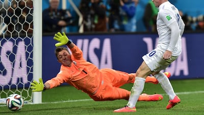 England forward Wayne Rooney, right, scores past Uruguay goalkeeper Fernando Muslera during the Group D football match at the Corinthians Arena in Sao Paulo on June 19, 2014, during the 2014 World Cup. Nelson Almeida / AFP