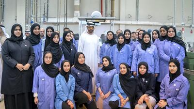 Sheikh Mohamed stands for a photograph with students.