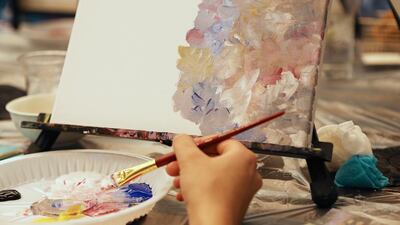A beginner hones painting skills at the Paint & Sip event held at Marriott Hotel Al Forsan in Abu Dhabi. Pawan Singh / The National