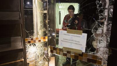 Members of the press are reflected on a broken mirror on January 11, 2016, while standing next to the door that leads to the tunnel entrance found inside the house where drug trafficker Joaquin “El Chapo” Guzman was hiding out before he was recaptured last Friday in Los Mochis, Mexico. Susana Gonzalez / Bloomberg