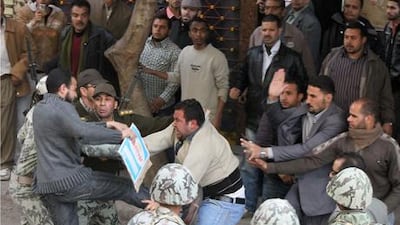 Egyptian soldiers try to protect a civilian from angry protestors who though he was a plainclothes policeman, on January 31, 2011 in Cairo?s Tahrir square during the biggest anti-government protests in three decades in a bid to topple President Hosni Mubarak's creaking regime. AFP PHOTO / KHALED DESOUKI