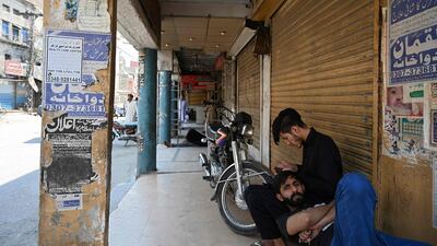 Shopkeepers sit outside in a market in Rawalpindi after Pakistan imposed a nine-day nationwide shutdown on May 8, 2021 to prevent a surge in Covid-19 cases during the Muslim holiday of Eid Al Fitr. AFP