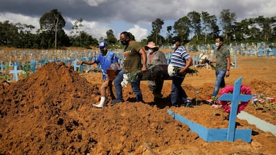 Sons of Veronica Ferreira, 73, who passed away due to the coronavirus disease (COVID-19), attend her burial at the Parque Taruma cemetery in Manaus, Brazil. Reuters