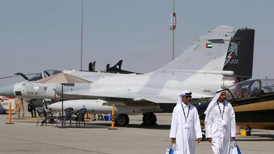 Visitors walk past a French-made Dassault Mirage 2000 fighter jet belonging to the UAE Air Force at the Dubai Airshow. Marwan Naamani / AFP