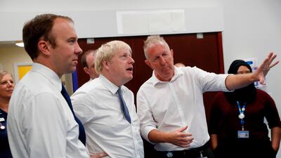 Britain's Prime Minister Boris Johnson, second from left, and Health and Social Care Secretary Matt Hancock, left, speak with staff members during a visit to an NHS hospital on Monday. AFP