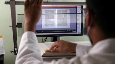 A worker scanning a book into digital format at the Juma Al Majid Centre for Culture and Heritage in Dubai. Pawan Singh / The National