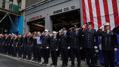 New York City Fire Department members stand outside Engine 10 and Ladder 10 firehouse for a moment of silence. AFP