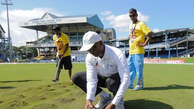 Umpire Gregory Brathwaite, centre, inspects the field during Day 3 of the fourth and final Test between West Indies and India at Queen's Park Oval in Port of Spain, Trinidad on Sauturday, August 20, 2016. Randy Brooks / AFP