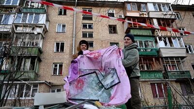 Residents remove debris after the explosion of a downed Russian drone. AFP