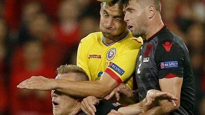 Dragos Grigore, centre, of Romania goes up for an aerial challenge. Robert Ghement / EPA