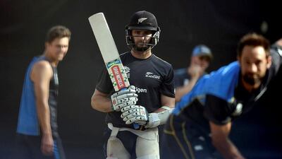 New Zealand's captain Kane Williamson, centre, watches as Grant Elliott bowls in the nets during a training session at Feroz Shah Kotla cricket ground in New Delhi on March 29, 2016, on the eve of the World T20 cricket tournament first semi-final match between England and New Zealand. / AFP / PRAKASH SINGH