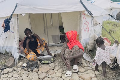 Displaced Sudanese who have returned from Ethiopia prepare food as they sit outside their tent in a UN camp at the border town of Gallabat. AFP