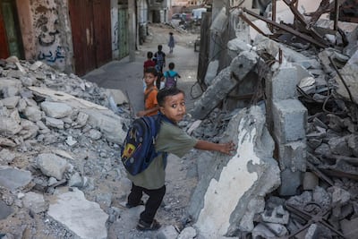 Palestinian children walk to school amid the rubble of destroyed buildings in Khan Younis, in the southern Gaza Strip. AFP