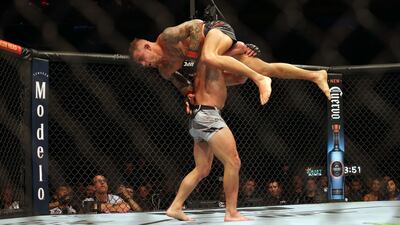Michael Chandler lifts Dustin Poirier during their lightweight fight at UFC 281. Getty