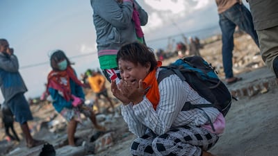 Residents react as rescuers recover the body of a tsunami victim in Palu. AP Photo