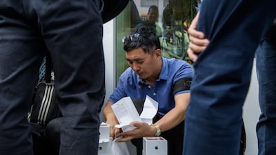 A reseller collects iPhone Xs with receipts near an Apple store in Hong Kong on November 3, 2017. AFP