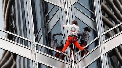 Frenchman climbs world's tallest tower, thrilling thousands.