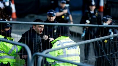 Police officers arrest a man who entered the grounds of the Houses of Parliament in London. AP
