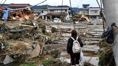 A woman looks at flood-damaged homes in Nagano, after Typhoon Hagibis hit Japan on October 12 unleashing high winds, torrential rain and triggered landslides and catastrophic flooding. Rescuers in Japan worked into a third day in an increasingly desperate search for survivors of a powerful typhoon that killed nearly 70 people and caused widespread destruction. AFP