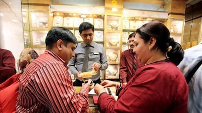 Indian tourists Vikram Mehta and his wife Priti buy jewellery, right, at a jewellery shop in the Gold Souk in Deira, Dubai. Pawan Singh / The National
