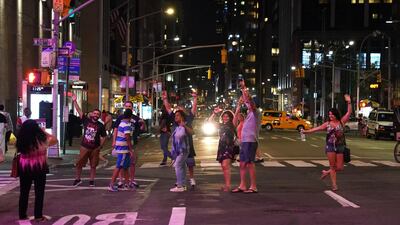 People celebrate on 6th Ave after the lights came back on. AFP