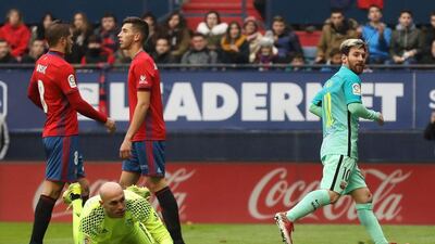 Lionel Messi, right, watches on as he scores Barcelona's second goal against Osasuna. Cesar Manso / AFP