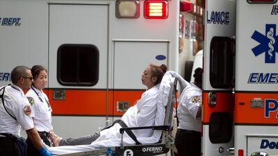 A woman, who exited the Marco Polo apartment complex, is placed in an ambulance as firefighters continue to battle the blaze at the high-rise in Honolulu. Marco Garcia / AP Photo