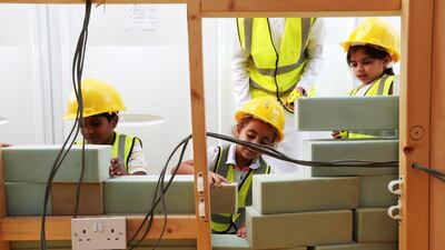Children construct a wall while taking part in a 'build it' activity. Christopher Pike / The National