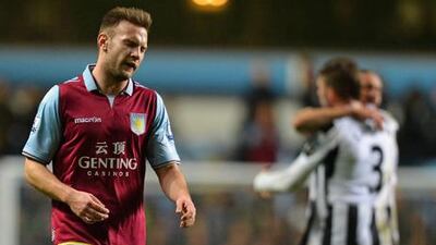 Aston Villa's Andreas Weimann shows the strain as Newcastle celebrate their victory.