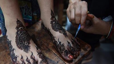 A Pakistani beautician applies henna designs to a customer ahead of the Eid Al Fitr holiday which marks the end of Ramadan at a beauty salon in Karachi. Muslims globally have been marking the month of Ramadan which ends with the Eid Al Fitr holiday. Asif Hassan / AFP photo