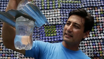 Illac Diaz holds a recycled plastic water container, left, and another container housing an inexpensive solar powered bulb. Both can be used to light homes for as long as five hours. Bullit Marquez / AP Photo