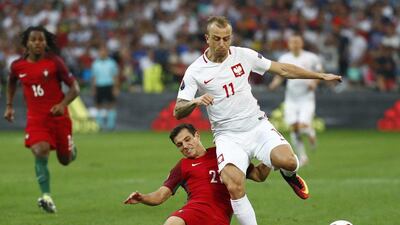 Poland winger Kamil Grosicki in action with Portugal defender Cedric. Kai Pfaffenbach / Reuters