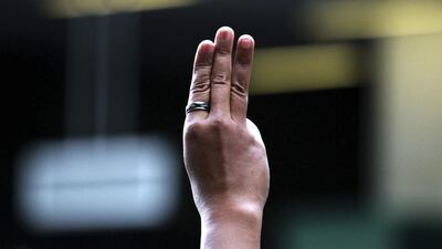 A protester flashes three fingers during an anti-coup demonstration at a shopping mall in Bangkok, Thailand on June 1, 2014. Hundreds of demonstrators shouting "Freedom!" and "Democracy!" gathered Sunday near a major shopping mall in downtown Bangkok to denounce the country's May 22 coup despite a lockdown by soldiers of some of the city's major intersections. Wason Wanichakorn/AP Photo