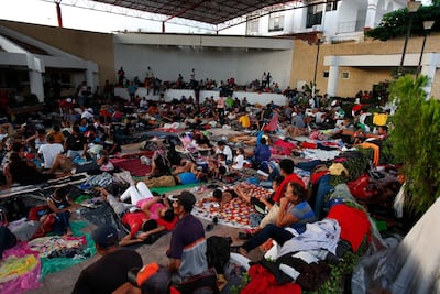 People rest as a thousand-strong caravan of Central American migrants heading for the US sets up camp for the night in Pijijiapan, Mexico. AP