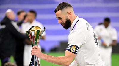 Real Madrid's French forward Karim Benzema grabs the Club World Cup trophy before the start of the match. AFP