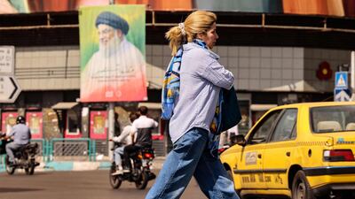 An Iranian woman walks past a billboard depicting slain Lebanese Hezbollah leader Hassan Nasrallah in Tehran on September 28. AFP