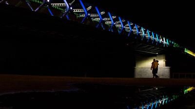 People pass the Old bridge illuminated by the light installation “Harmony” created by Slovak artists Ondrej Maksi and BN Label, during The White Night, a night-time art festival in Bratislava, Slovakia. AFP