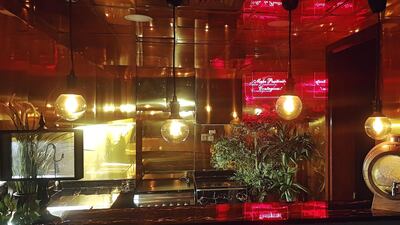 A custom-made sign with a pink neon light reads “Make Positivity Contagious!”, and is reflected across the surfaces in the kitchen. Photo by Areeb Hassan