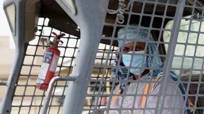 An expatriated worker wears a mask while working at a factory in Salmabad village south of the Bahraini capital Manama. AFP