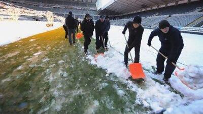 Newcastle ground staff attempt to clear the pitch of snow in time for today’s visit of Chelsea to St James’ Park.